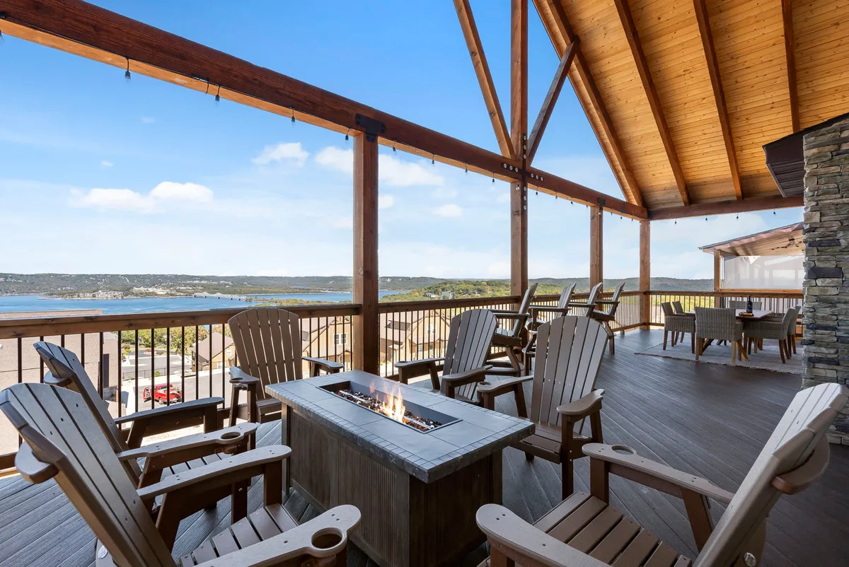 This cozy exterior scene centers around a communal fire pit, flanked by Adirondack chairs and offering a scenic view of the outdoors. The warm glow and arrangement invite gathering and relaxation, especially in the evenings.